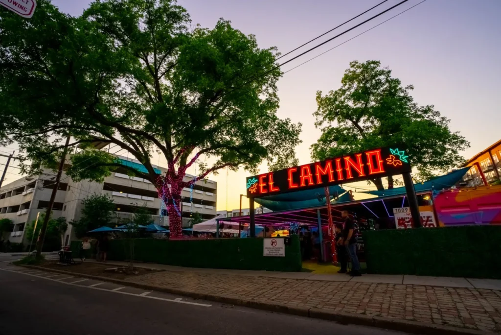 alt="El Camino food truck park in San Antonio at night"